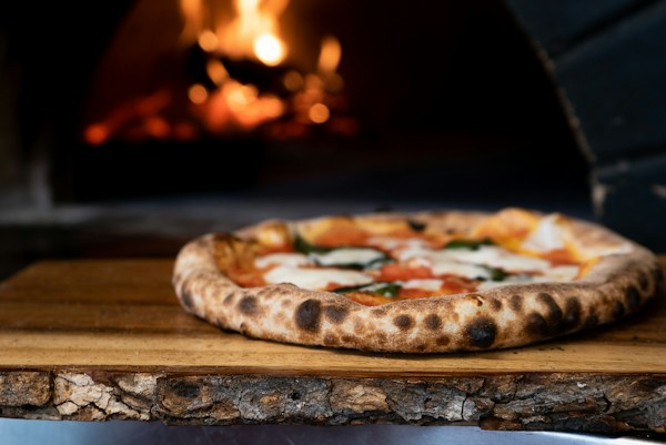 Freshly baked pizza with basil and tomato